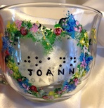 Glass mug 14oz. with Heartshape garland of various color flowers. In center has name in braille and script